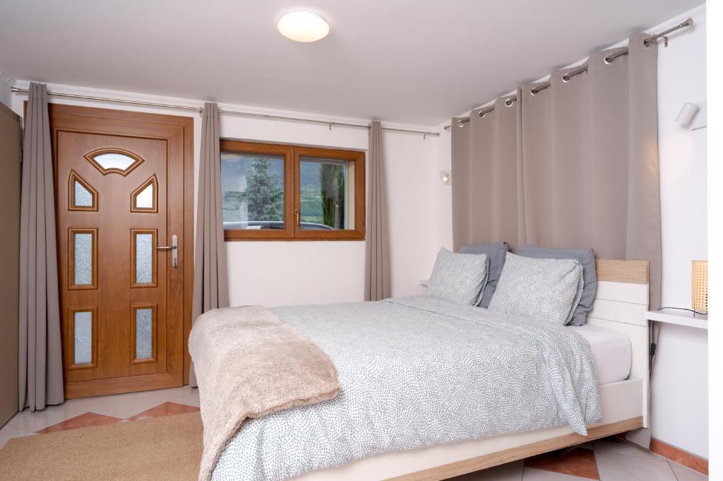 a bedroom with a bed and a window and a door at Maison les Mésanges in Flanthey