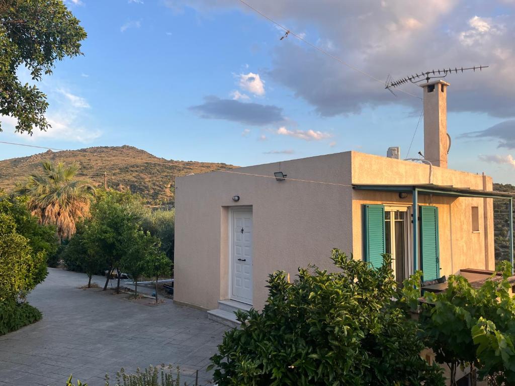 a building with a door and a mountain in the background at Golden Hour on the Hill in Aegina