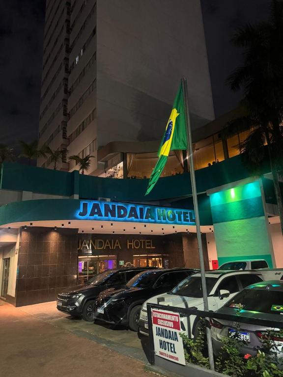 a jordanian hotel with cars parked in a parking lot at Jandaia Hotel Campo Grande in Campo Grande