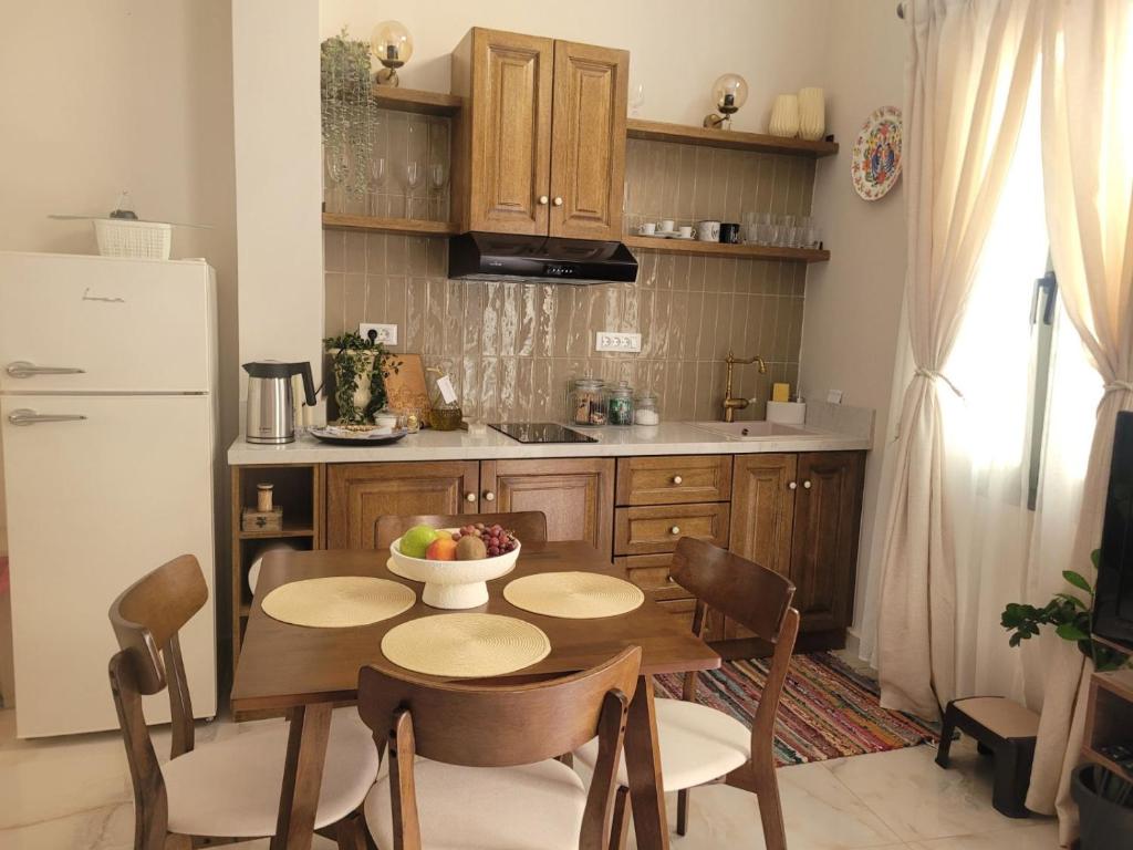 a kitchen with a table with a bowl of fruit on it at City Center Suites in Karpathos