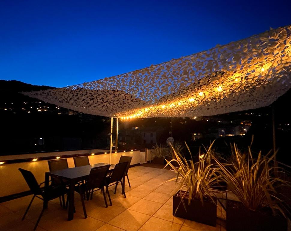 a table and chairs on a balcony at night at Top Stay Retrò in Costa Volpino