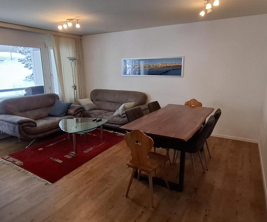 a living room with a table and a couch at Ferienwohnung in den Flumserbergen in Flumserberg