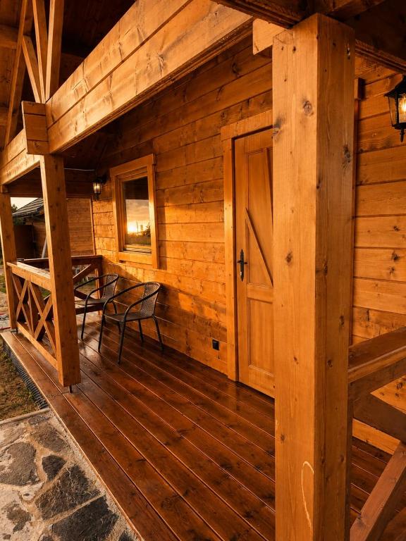 a wooden cabin with a table and a door at Podhalańskie Chaty in Rokiciny Podhalanskie