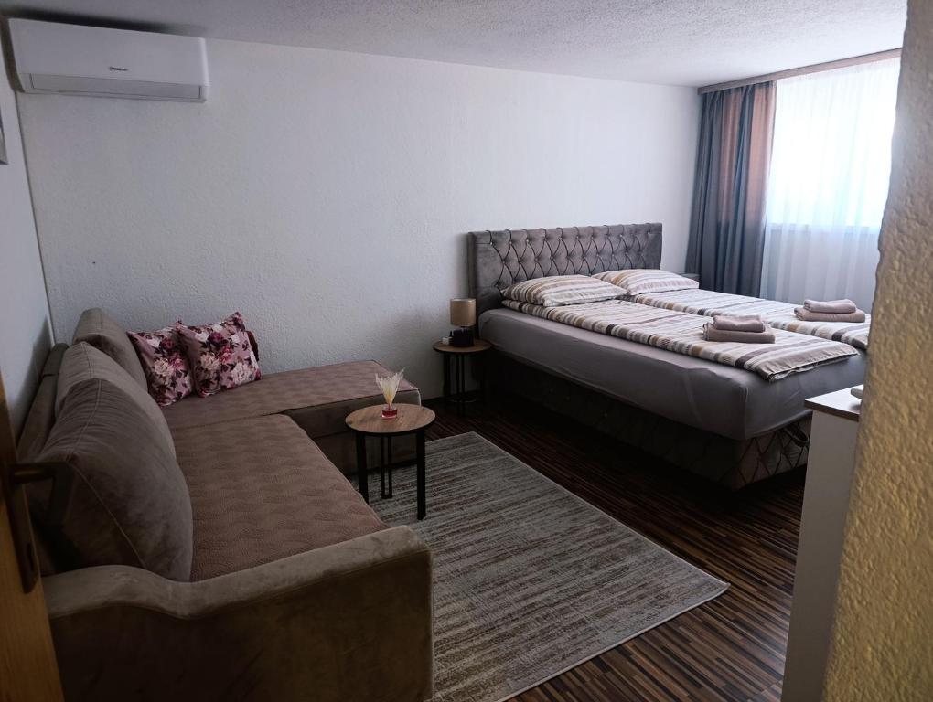 a living room with a couch and a bed at Apartman 4A in Bihać
