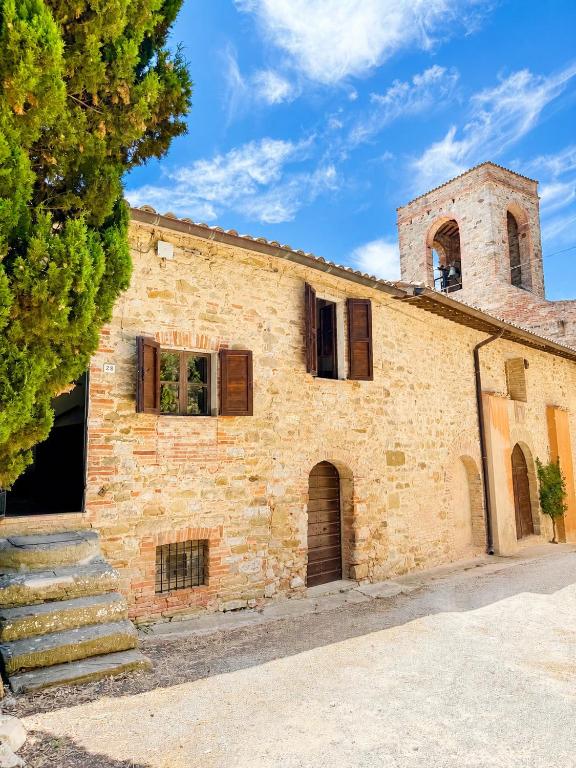 an old brick building with a tower on top at Castello di Mongiovino Vecchio "La Casa in Piazza" in Panicale