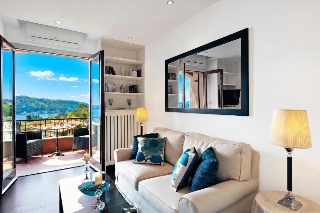 a living room with a couch and a mirror at Brentano Elegante in Mezzegra
