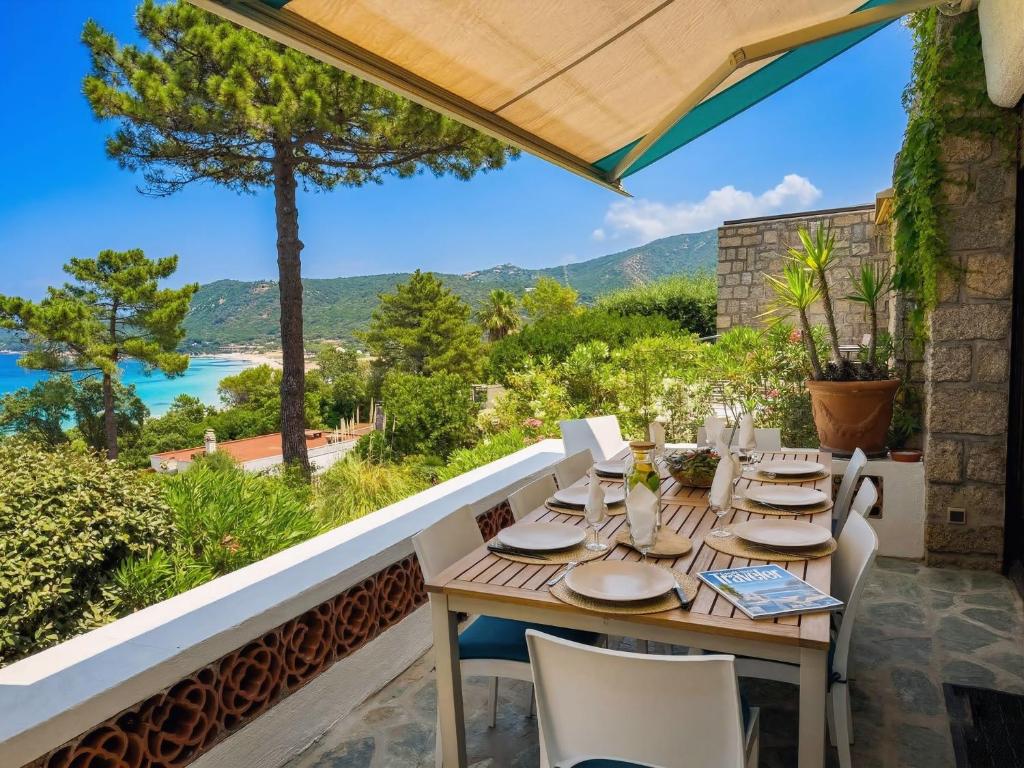 a table on the balcony with a view of the water at Villa Aster in Coti-Chiavari