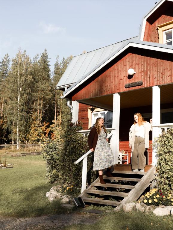 two women standing on the steps of a red barn at Kolin Mattila B&B in Kolinkylä