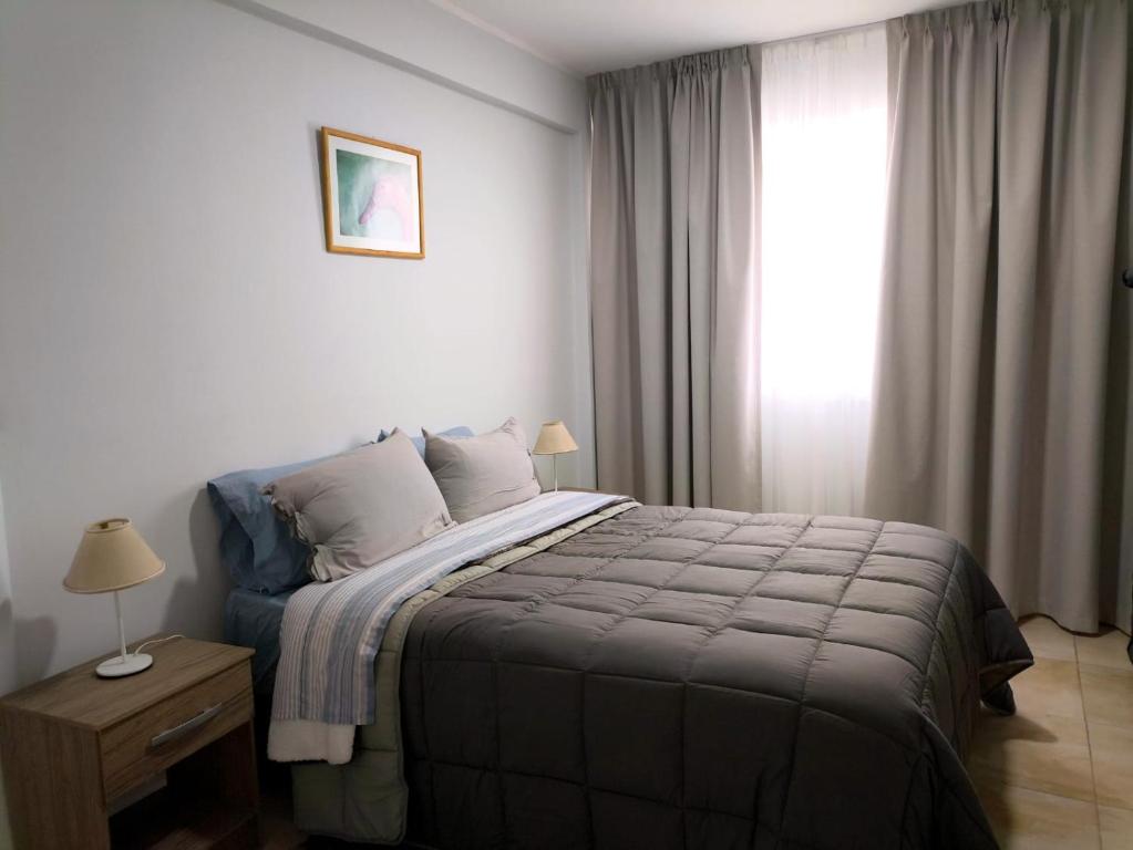 a bedroom with a large bed and a window at Departamento Letty Petit - Con Cochera in San Salvador de Jujuy