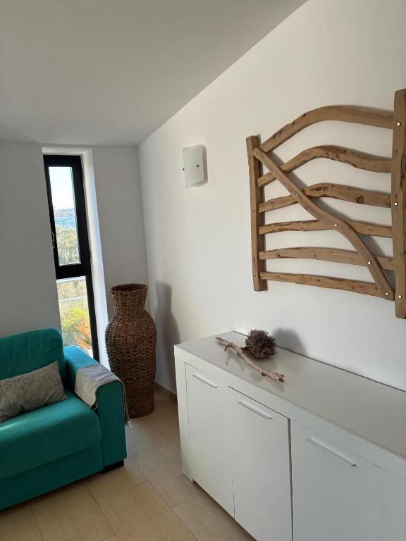 a living room with a green chair and a staircase at Apartamento Sa Perdiu 16 in Son Carrio
