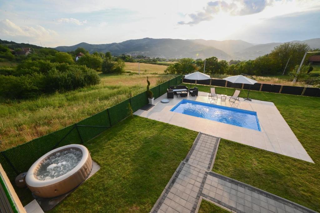 an image of a backyard with a tub in the grass at Koala Resort in Raška