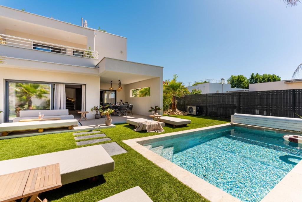 a backyard with a swimming pool and a house at Villa Maya Rooftop beach access heated pool in Le Grau-dʼAgde
