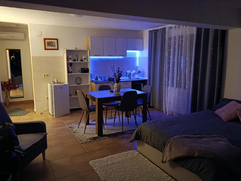 a living room with a dining room table and a kitchen at Studio apartman EMA in Brodski Varoš