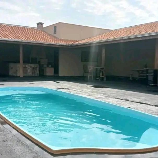 a large blue swimming pool in front of a house at Estância Bonanzza Barretos in Barretos