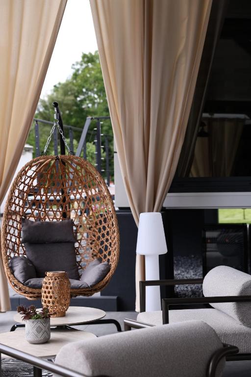 ein Zimmer mit einem Rattanstuhl und einem Tisch in der Unterkunft Glamping L tiny , 2Ferienhäuser mit stillvolles Design und hohem Komfort Sauna Hot Tub in Platten