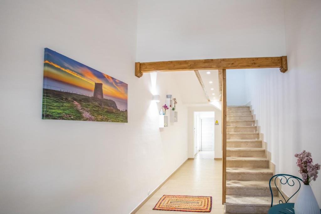 a hallway with stairs and a painting on the wall at GioLì in Matino