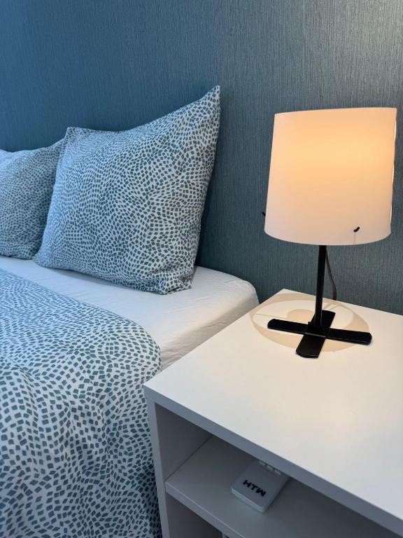 a lamp on a night stand next to a bed at Dormitorio no Porto in Porto