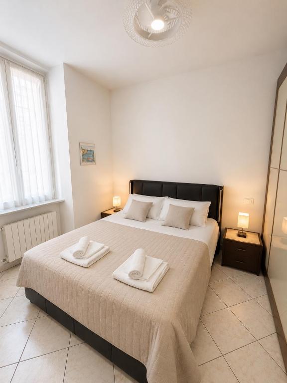a bedroom with a large bed with two towels on it at Casa DELUXE -50m dal mare- in Alassio
