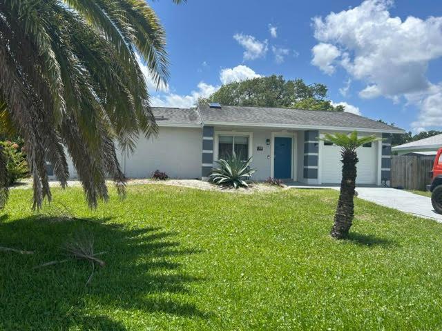 a house with a palm tree in a yard at Blue Beach Pool House in Port Orange