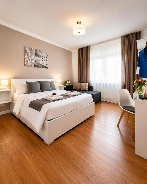 a bedroom with a large white bed and a living room at Corso Venezia in Mestre