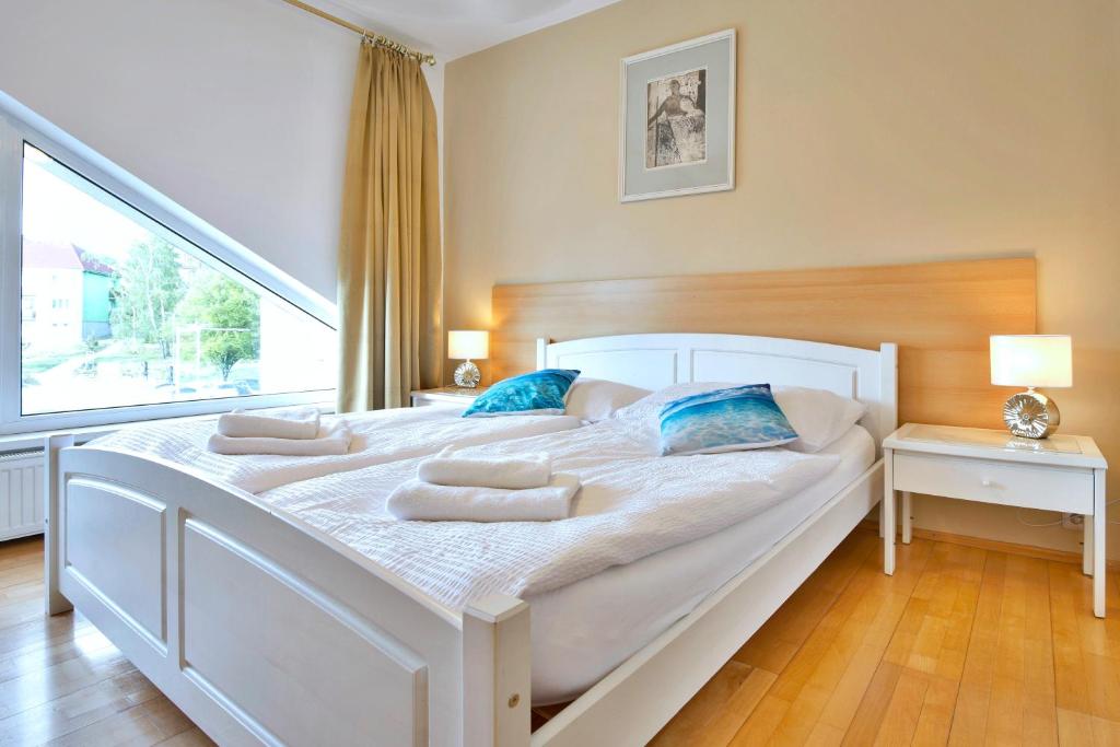 una cama blanca grande en una habitación con ventana en Hotel Monaco, en Náměšť nad Oslavou