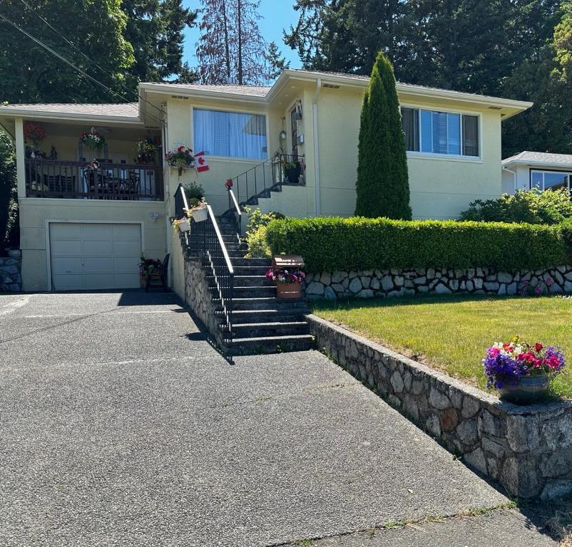 a house with a stone retaining wall and a driveway at Victoria BNB in Victoria