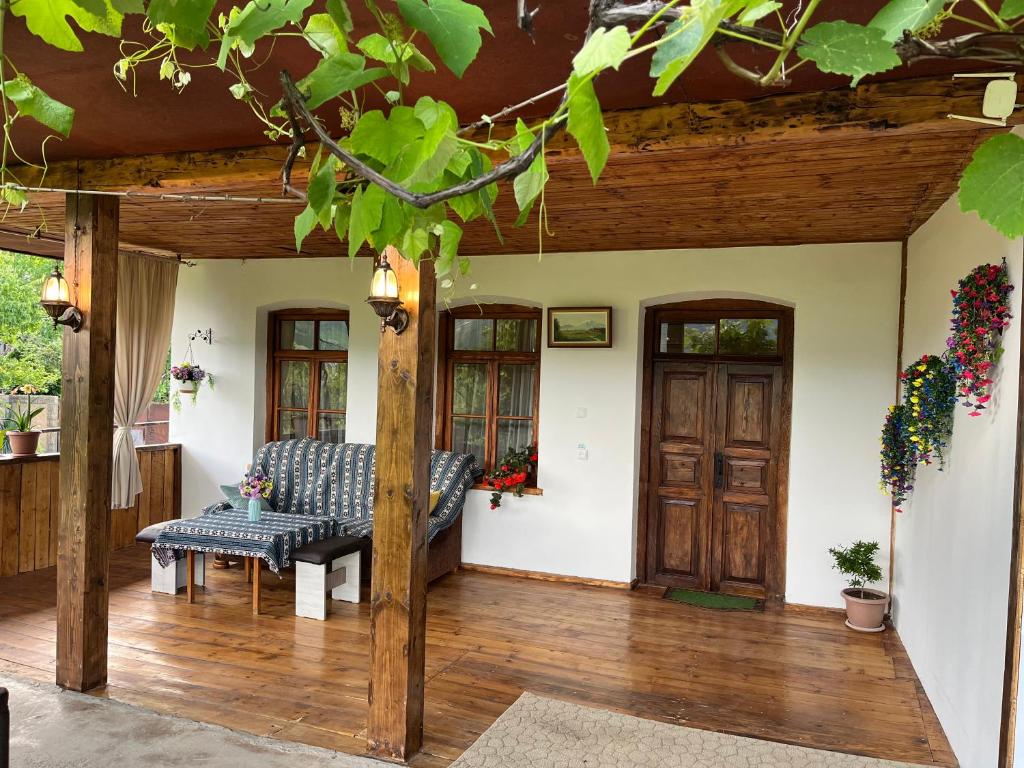 a porch with a bench on a wooden deck at Harmony Guest House in Ijevan