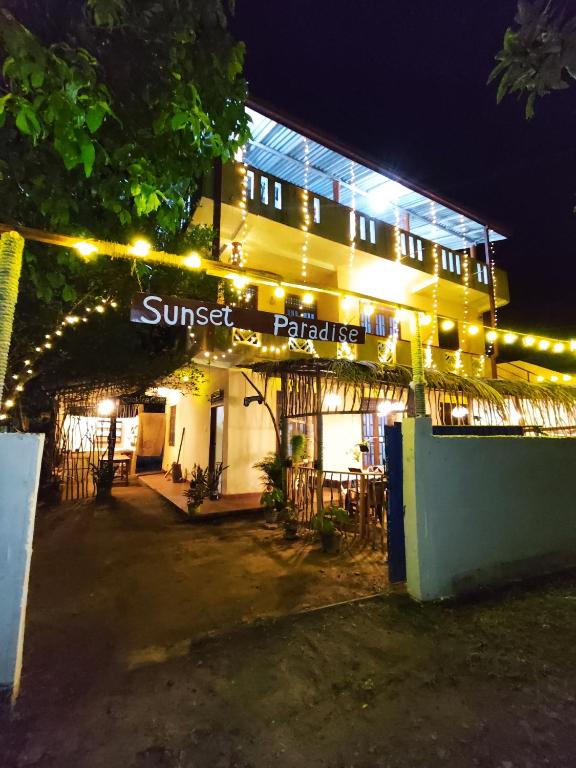 a building with a sign that reads sunset paradise at night at Sunset Paradise Talalla in Talalla South