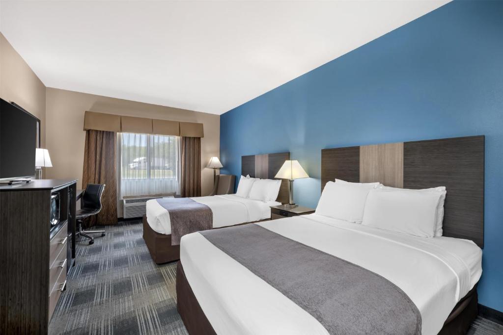 a hotel room with two beds and a flat screen tv at Best Western Geneseo Inn in Geneseo