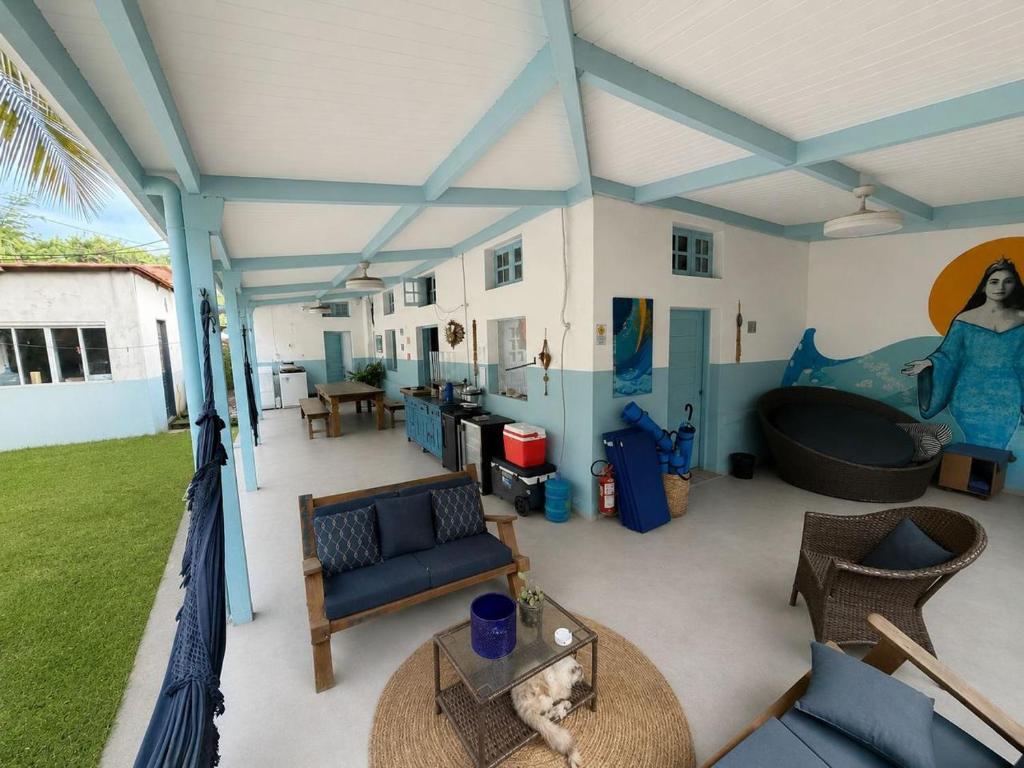 a covered patio with a couch and a bath tub at Estrela Praia in Fernando de Noronha