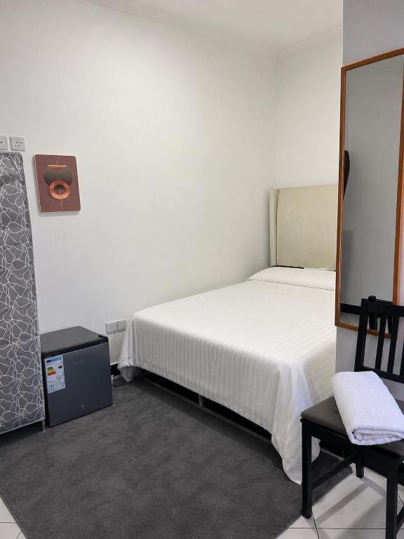 a bedroom with a bed and a chair and a mirror at Central Calm Apartment in Dar es Salaam