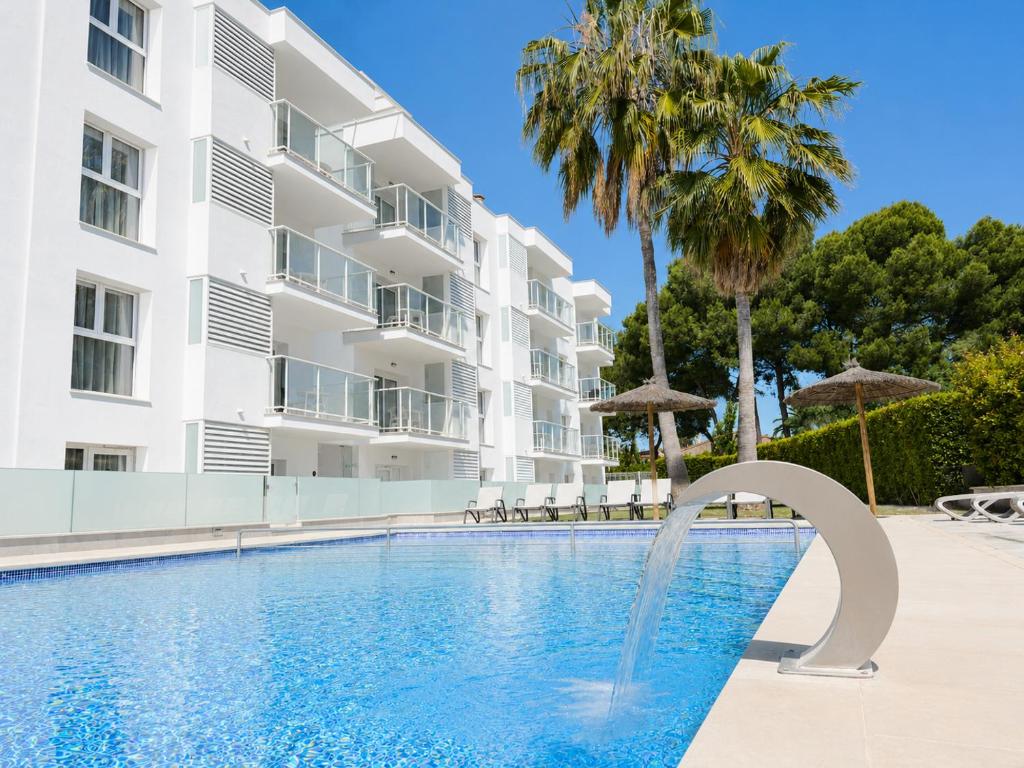 a swimming pool with a fountain in front of a building at Rentalmar Pins Marina in Cambrils