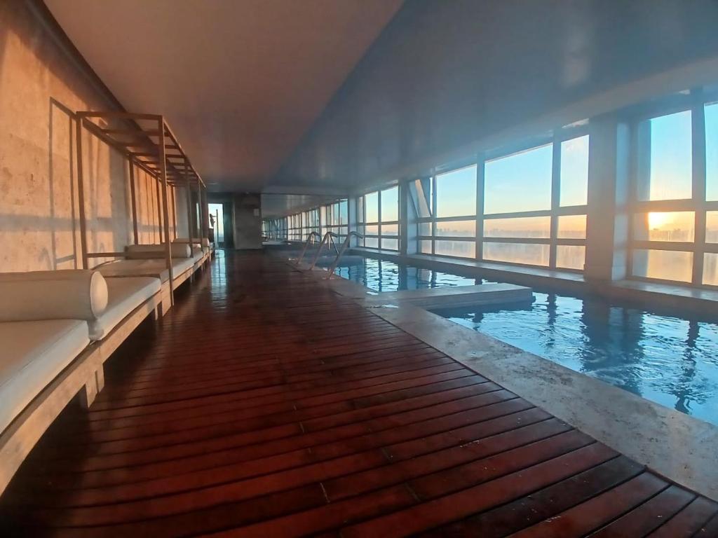 a large swimming pool in a building with windows at Quartier San telmo Piscina climatizada y Spa premium in Buenos Aires