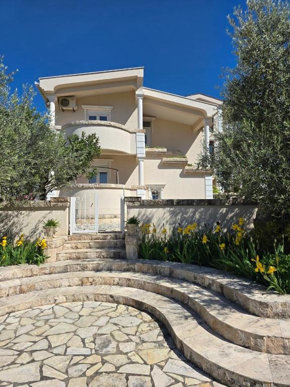 a house with a stone staircase in front of a house at Villa Crown Silvia in Dobra Voda
