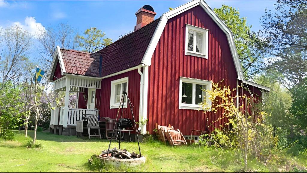 a red house with a chimney on top of it at Hus Hultsnäs in Högsby
