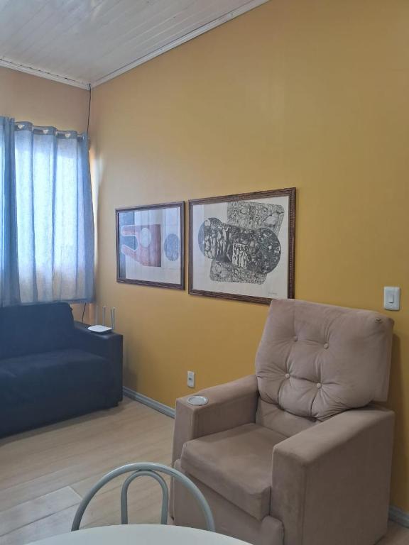a living room with a couch and a chair at Ground floor apartment steps from the Cathedral in Santo Ângelo