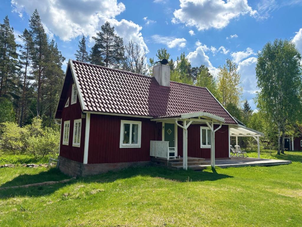 a small red house on a grassy field at Hus Kråksmåla in Alsterbro