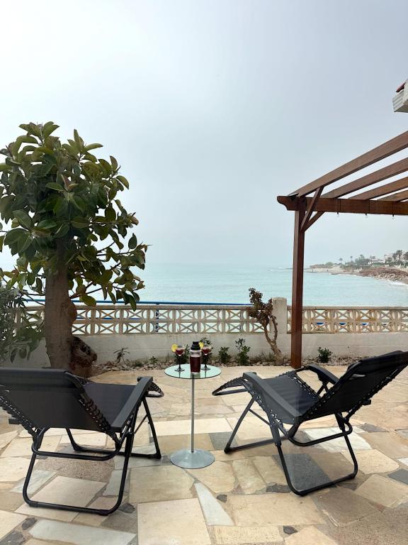 two chairs and a table in front of the ocean at Villa Blue Paradise in Vinarós