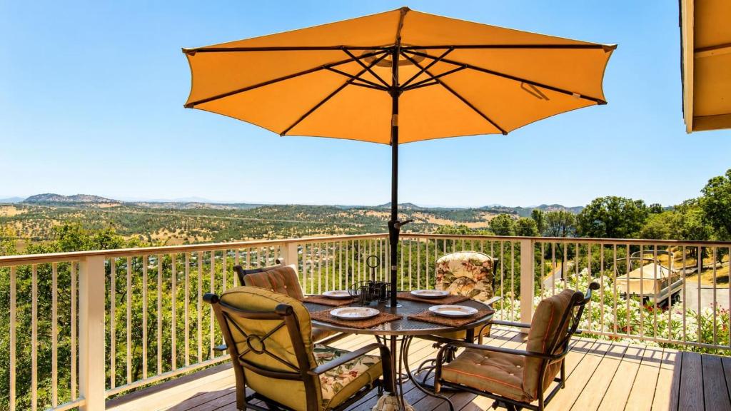 a table and chairs with an umbrella on a deck at Copperopolis Home - Lake Access & Mtn Views in Copperopolis