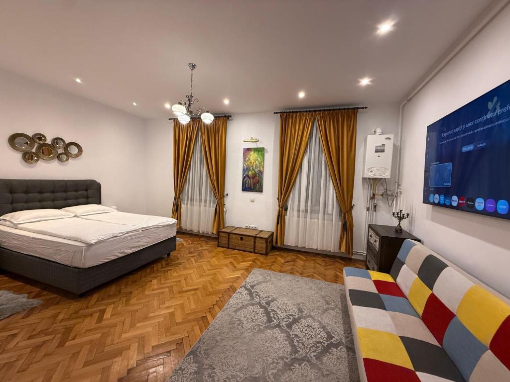 a bedroom with a bed and a flat screen tv at Insieme Studio - Small Square in Sibiu