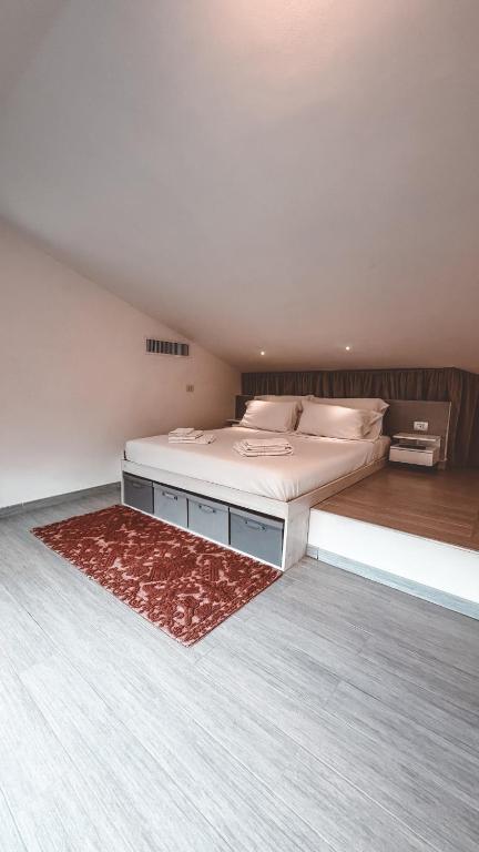 a bedroom with a large bed with a red rug at NURAS - Casa degli Anemoni in Porto Conte