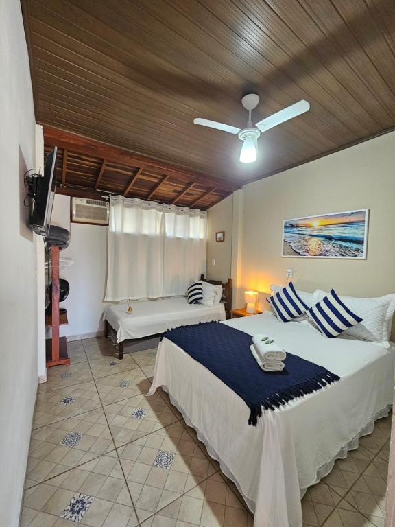 a bedroom with two beds and a ceiling fan at Flat Sol Paraty in Paraty