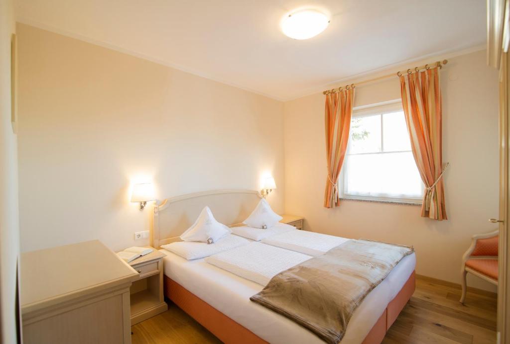 Un dormitorio con una cama grande y una ventana en Gutshof Sinn, en Caldaro