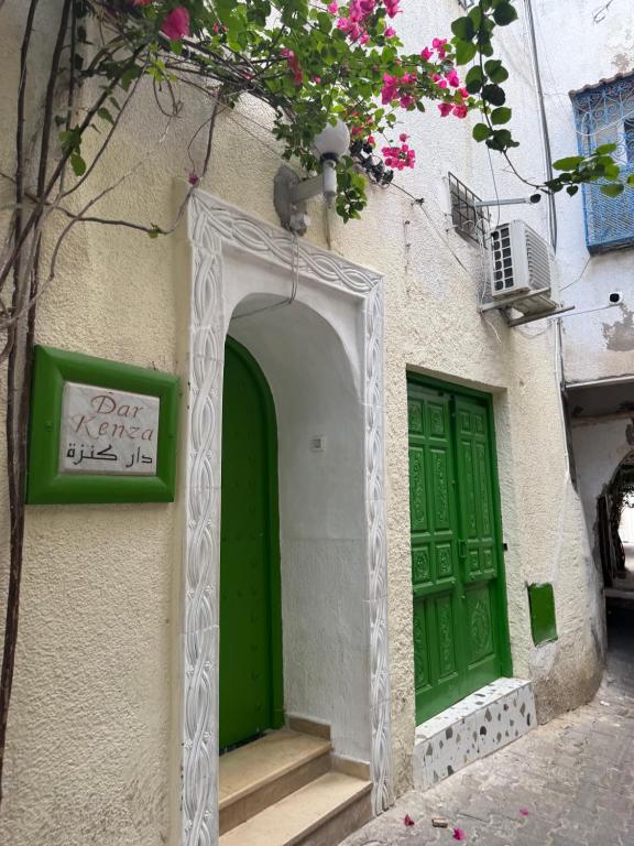 a building with green doors and a sign on it at Dar kenza Tunis in Tunis