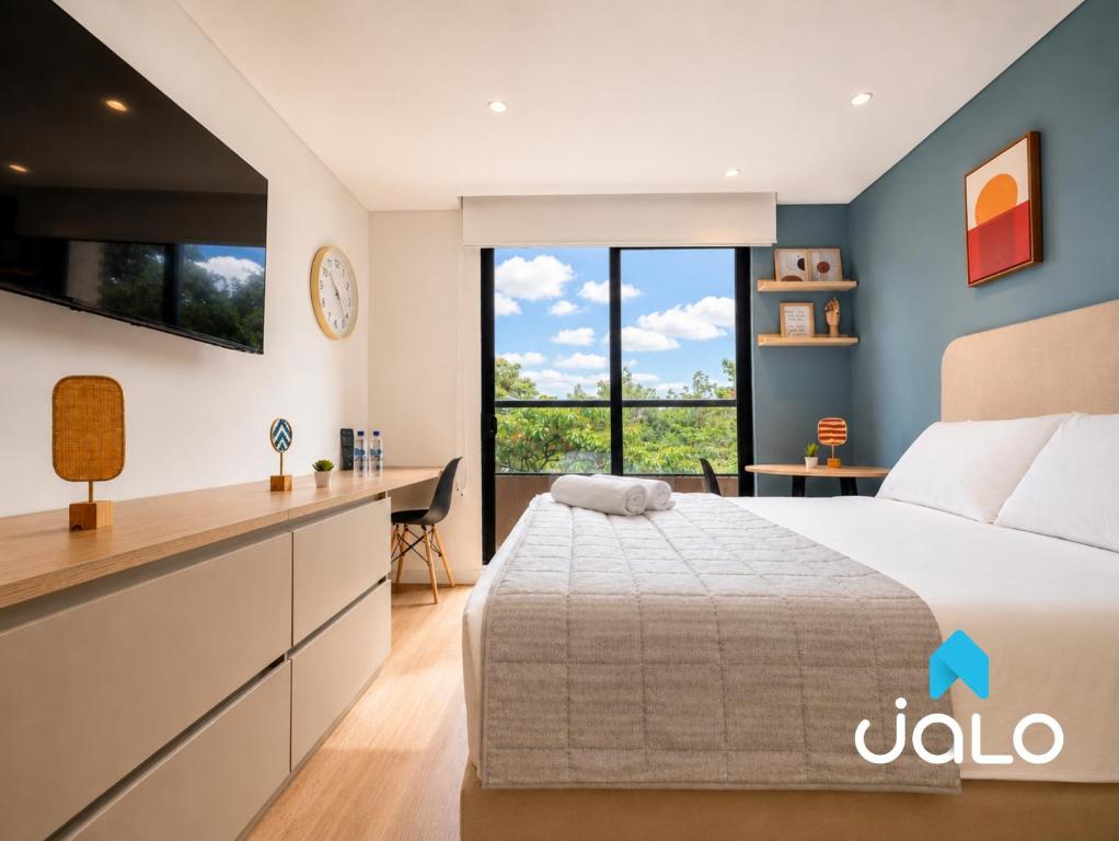 a bedroom with a large bed and a desk at Well 100 by JALO in Bogotá
