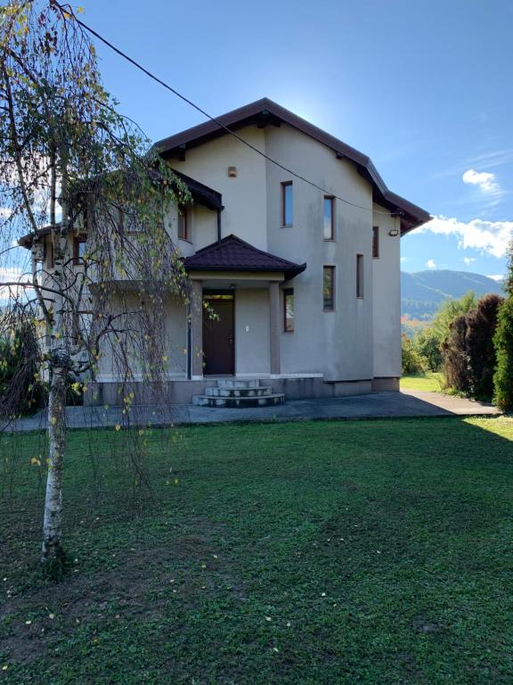 a large white house with a grass yard at Villa Emina in Košelji