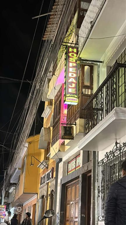 a building with neon signs on the side of it at Hospedaje LA RESIDENCIA in Ayacucho