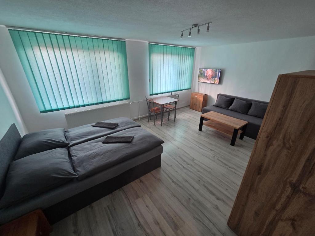 a bedroom with a bed and a couch and a table at Penzión Poloniny in Ulič