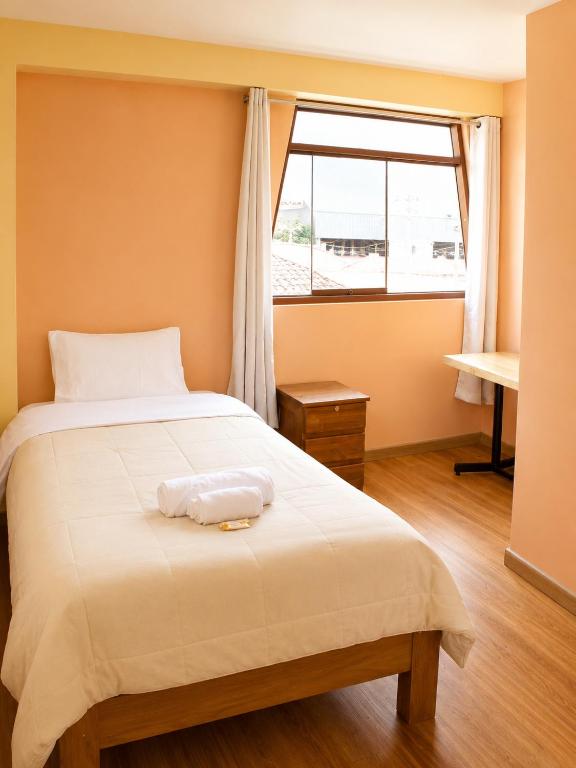 a bedroom with a large bed with a window at Imasmari Wasi in Pisac