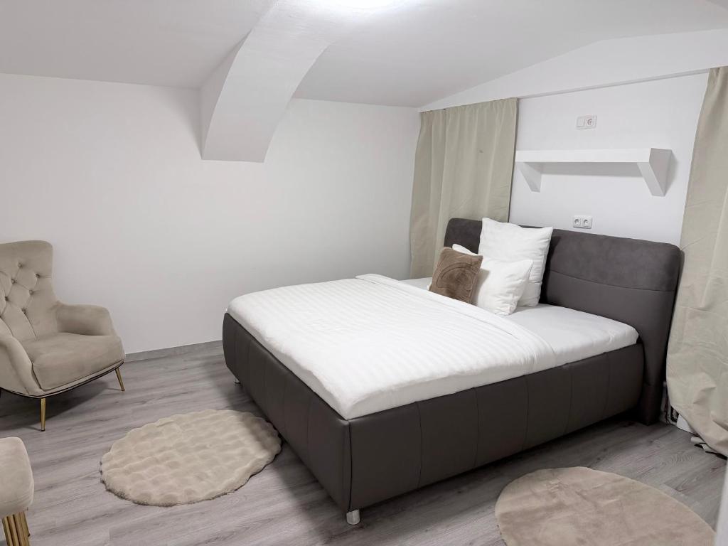 a bedroom with a large bed and a chair at Eliasar2 in Linz